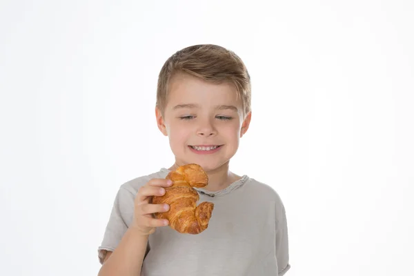 A boy and a croissant — Stock Photo, Image