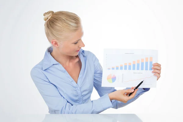 Blond business woman pointing a chart with pen — Stock Photo, Image