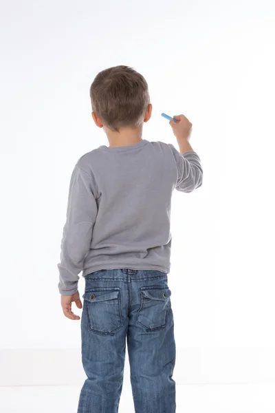 Niño pensando con tiza en la mano — Foto de Stock
