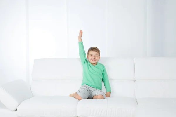 Isolated young kid on white sofa — Stock Photo, Image