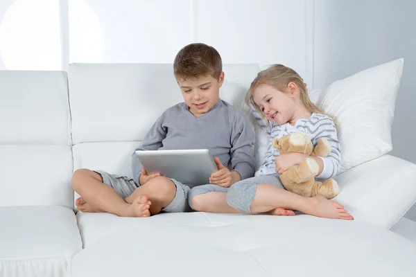 Hermano y hermana en sofá blanco — Foto de Stock