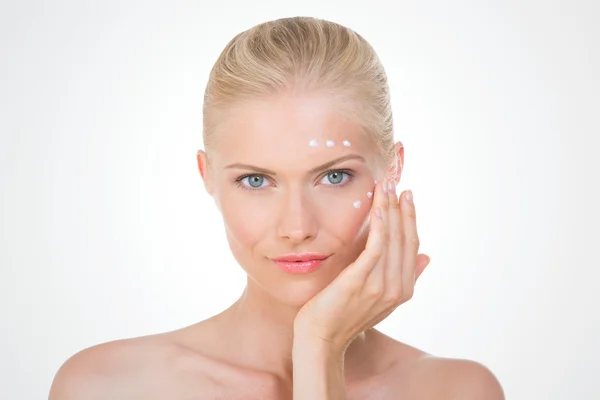 Nordic girl applying salve on her face — Stock Photo, Image