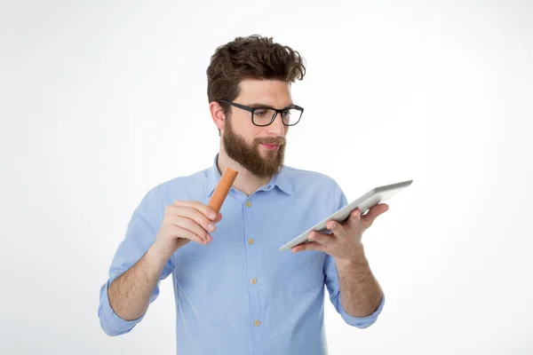 Young man eating junk food during work — Stock Photo, Image