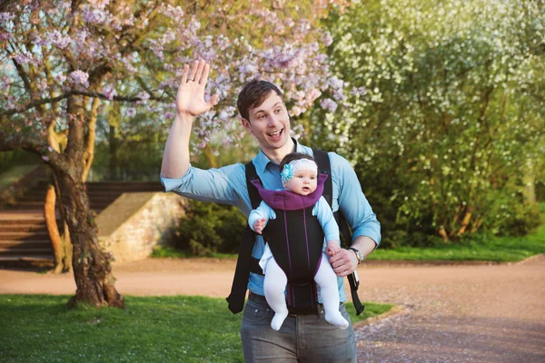 Padre llevando hija pequeña con canguro en parque —  Fotos de Stock