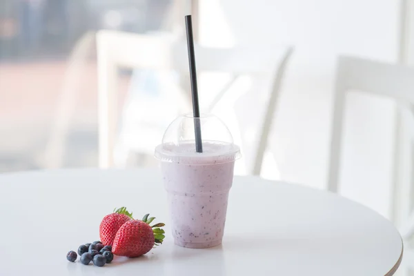 Smoothie çilek ve blackbe ile masada plastik kap içinde