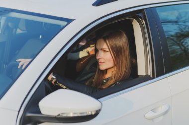 Güzel bir kadın araba kullanıyor.