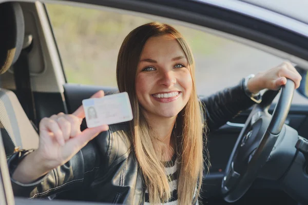 Atractiva joven mujer orgullosamente mostrando su licencia de conducir — Foto de Stock