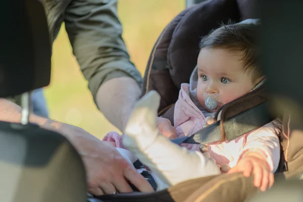 Een vader zijn dochter in haar autostoel in de auto brengen — Stockfoto