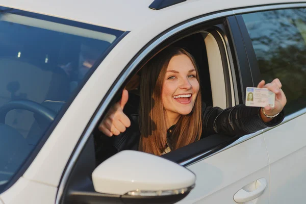 Çekici genç kadın gururla onun sürücüleri gösterilen Lisans — Stok fotoğraf