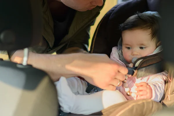 Egy apa lánya baba üzembe ő autó ülés az autóban — Stock Fotó