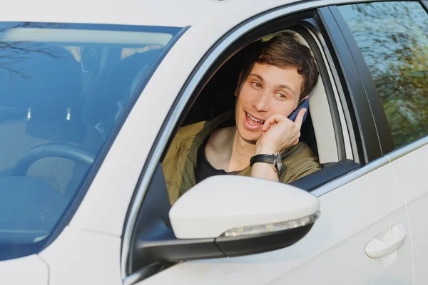 Knappe man in auto praten op mobiele telefoon — Stockfoto