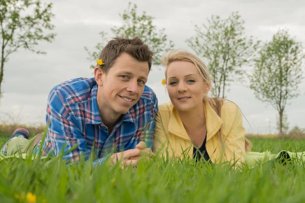 Schönes Paar liegt im Gras — Stockfoto