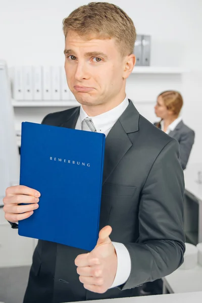 Schöner Mann im Anzug hält Mappe mit deutscher Aufschrift in der Hand " — Stockfoto