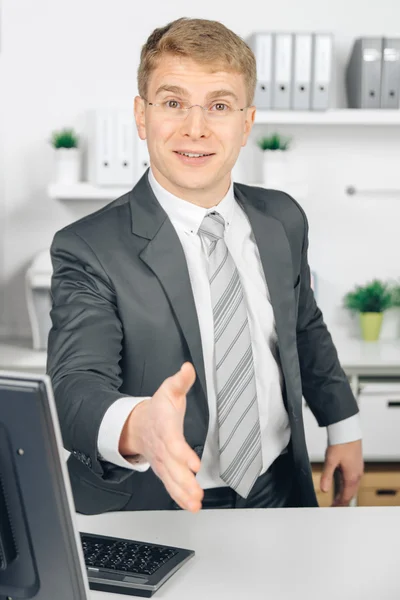 Attraktiv business man giving a hand in office — Stock Photo, Image