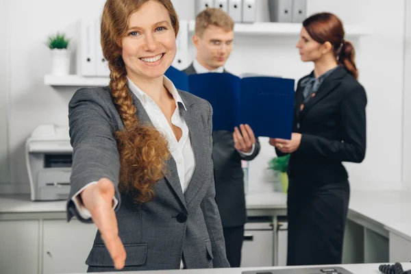 Mujer de negocios que da una mano en la oficina — Foto de Stock