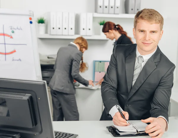 Empresário tomar notas e sorrisos — Fotografia de Stock