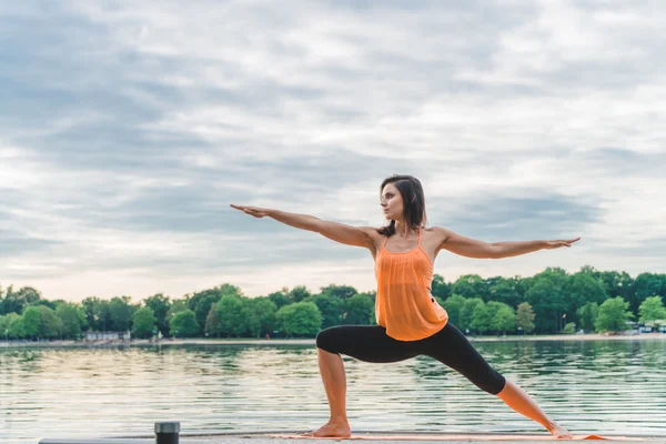 Giovane donna che fa yoga sul lago — Foto Stock