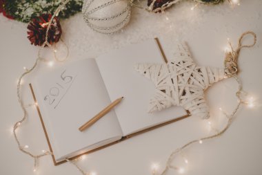 Not defteri bir kalem, mum ve yılbaşı dekor ile yazılmış 2015