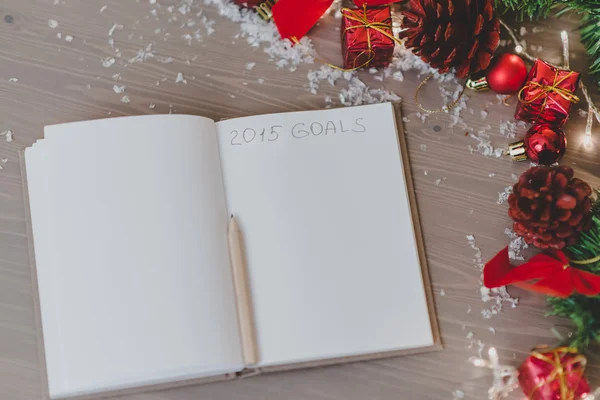 Kladblok met een decoratie van het pensil en xmas geschreven 2015-doelstellingen — Stockfoto