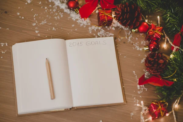Notepad with a pensil and xmas decoration written 2015 goals — Stock Photo, Image