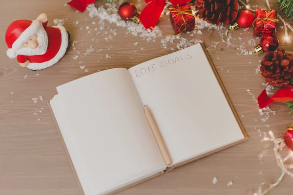 Notepad with a pensil and xmas decoration written 2015 goals — Stock Photo, Image