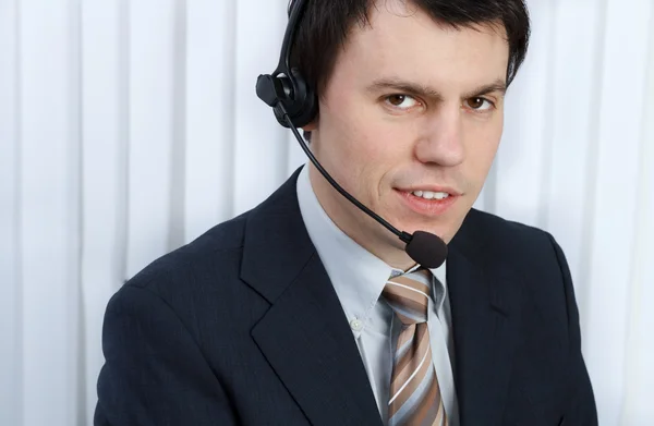 Business man in office speaks on headset — Stock Photo, Image