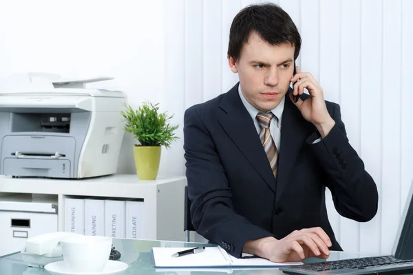 Homem de negócios no escritório fala por telefone — Fotografia de Stock