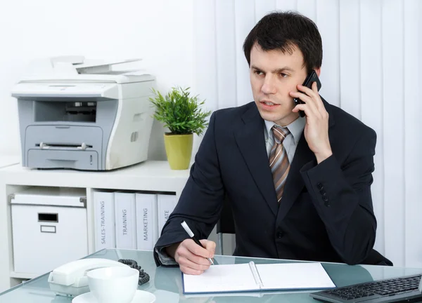 Бизнесмен в офисе говорит по телефону — стоковое фото