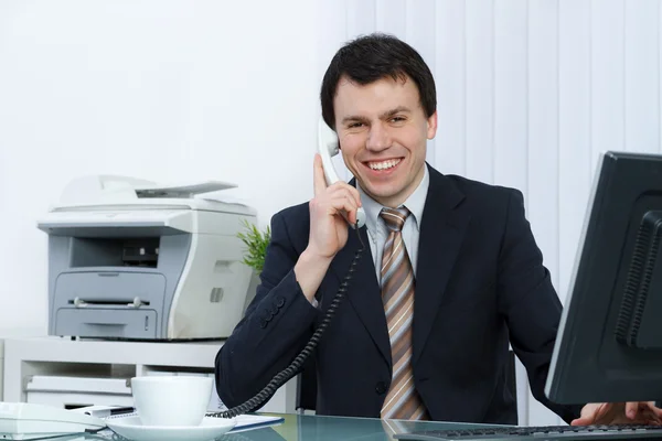 Homem de negócios no escritório fala por telefone — Fotografia de Stock