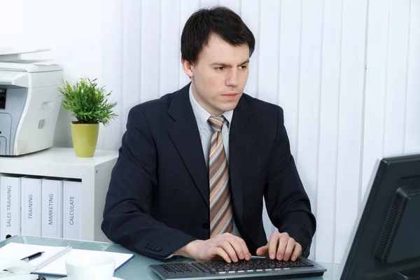 Homem de negócios no escritório trabalha no computador — Fotografia de Stock