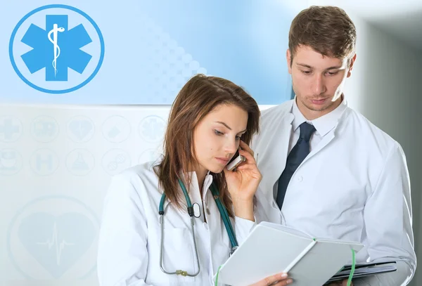 Two doctors consulting on telephone at the clinic — Stock Photo, Image