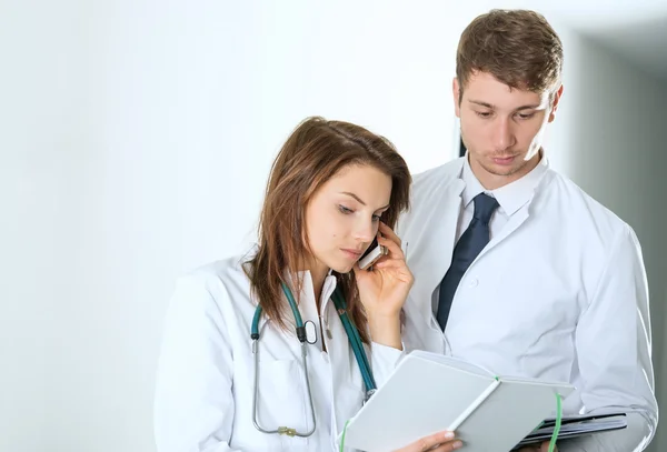 Two doctors consulting on telephone at the clinic — Stock Photo, Image