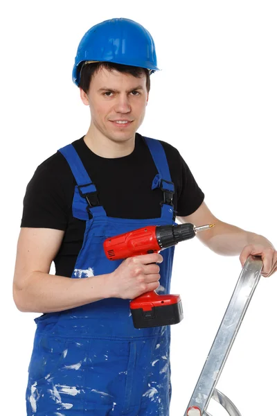 Handyman sonriendo a la cámara sosteniendo el taladro — Foto de Stock