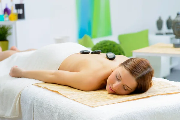 Beautiful woman in spa salon during a stone therapy — Stock Photo, Image