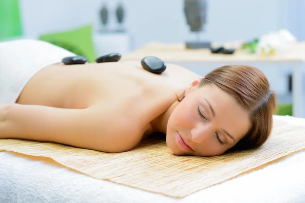 Beautiful woman in spa salon during a stone therapy — Stock Photo, Image