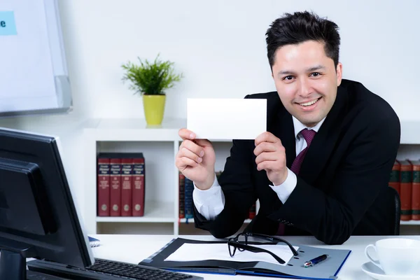 Attractive business man in office holding a blank card — Stock Photo, Image