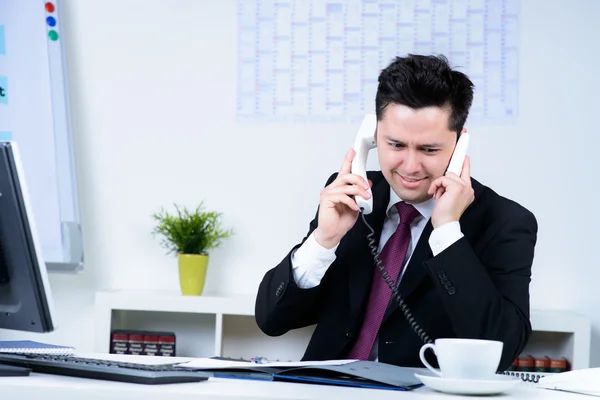 Attractive business man overloaded at work in office — Stock Photo, Image