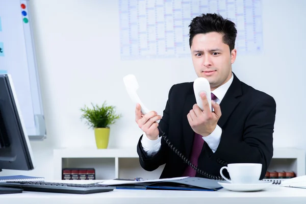 Homem de negócios atraente sobrecarregado no trabalho no escritório — Fotografia de Stock