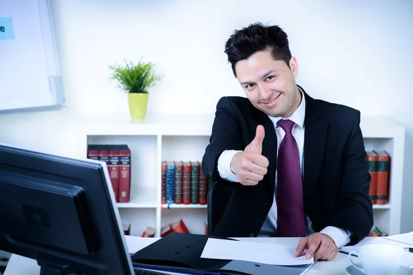 Привлекательный бизнесмен в офисе показывает большой палец вверх — стоковое фото