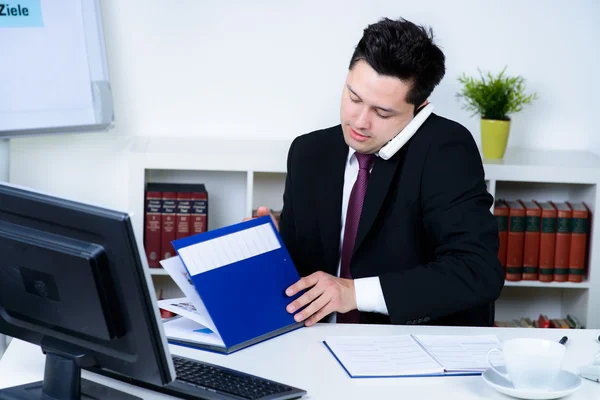 Attraktiver Geschäftsmann im Büro am Telefon — Stockfoto