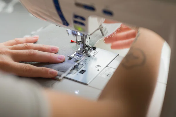 Fermer les mains de la femme couture sur la machine à coudre — Photo