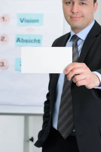 Young man in suit with business card — Stock Photo, Image