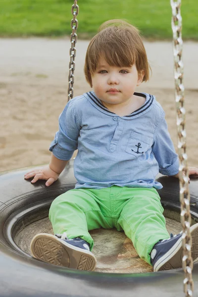 Mignon petit garçon sur une balançoire — Photo