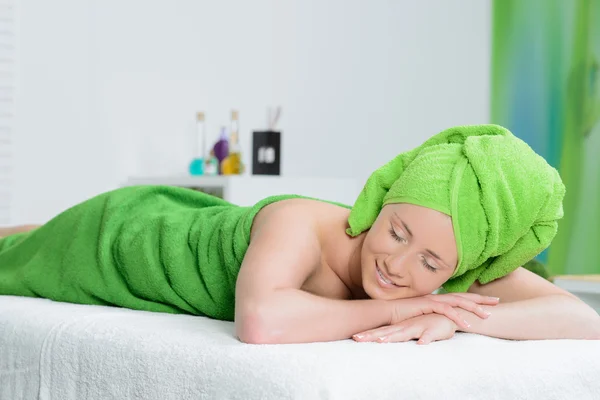 Güzel kadın spa salonda yeşil havlu sarılı — Stok fotoğraf
