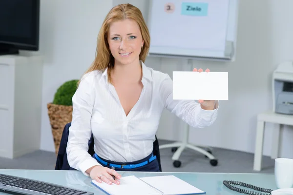 Mooie vrouw op kantoor toont blanco visitekaartje — Stockfoto