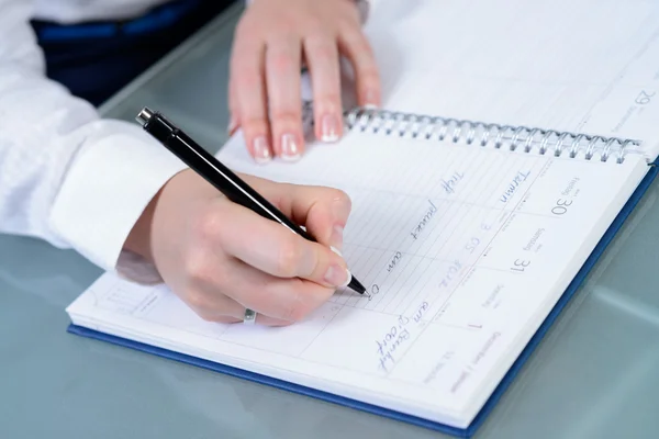 Mujer manos escribiendo planes en el cuaderno — Foto de Stock