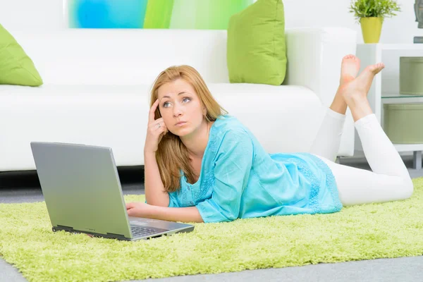 Schöne Frau zu Hause auf dem Boden liegend mit Laptop — Stockfoto