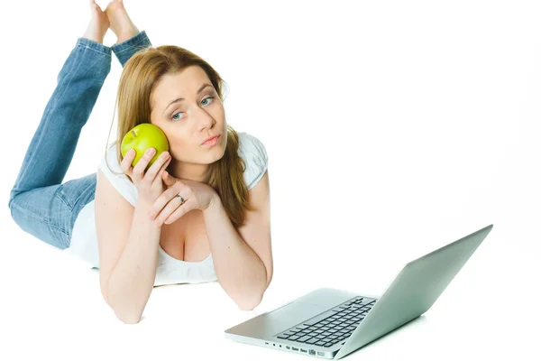 Atractiva mujer joven tendida en el suelo con un ordenador portátil y una aplicación —  Fotos de Stock