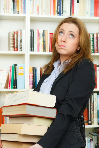 Joven estudiante en biblioteca con libros — Foto de Stock