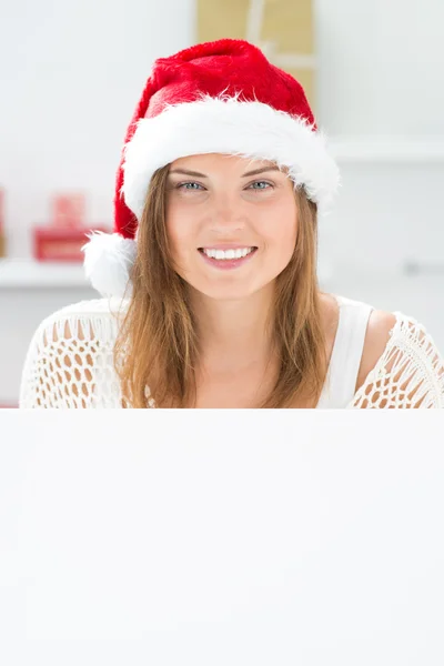 Santa girl peeking from behind blank sign billboard. Advertising